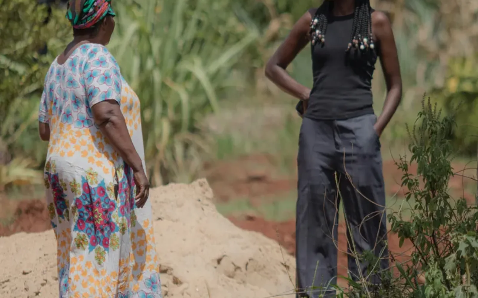 Two Kenyan farmers discussing farming practices in a field